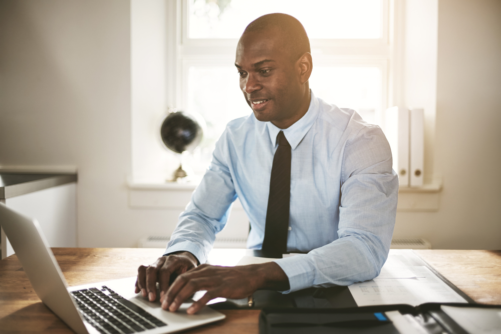 successful,young,african,executive,sitting,at,his,desk,in,an